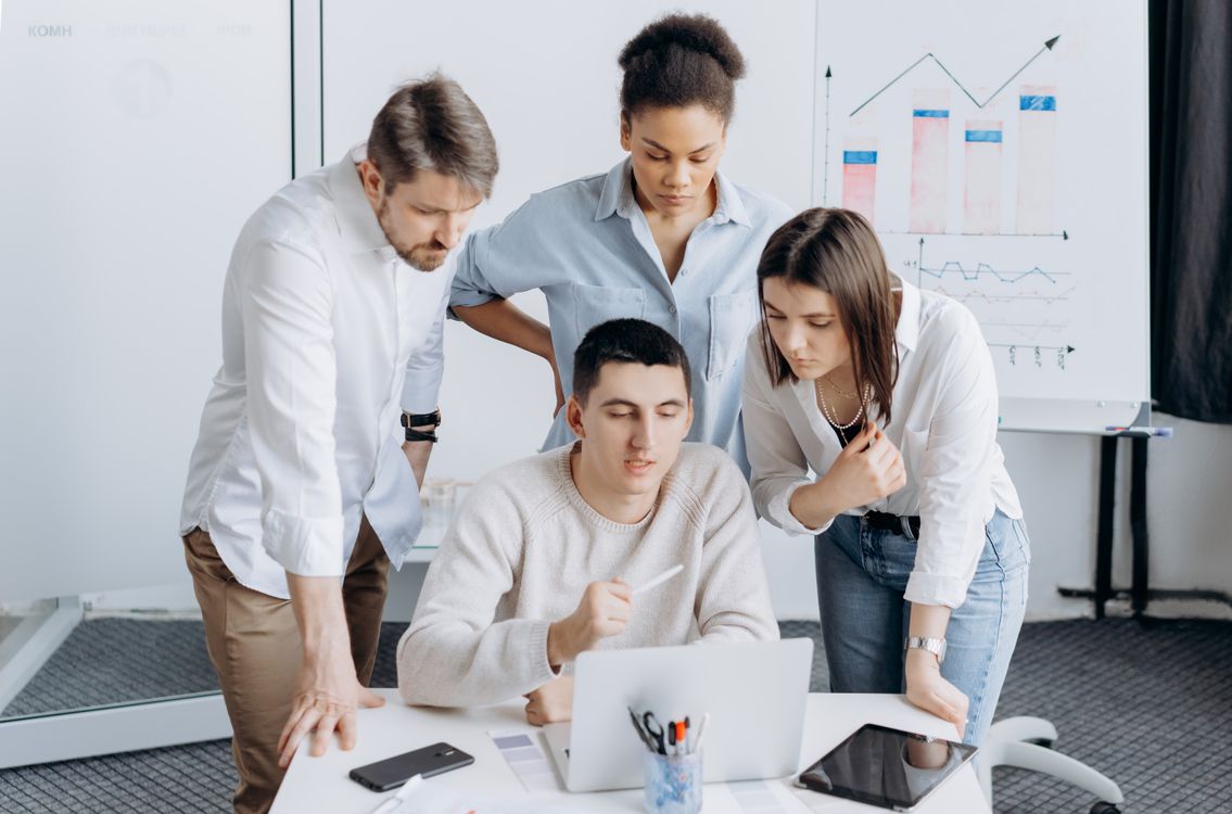 Team reviewing a problem together at a laptop